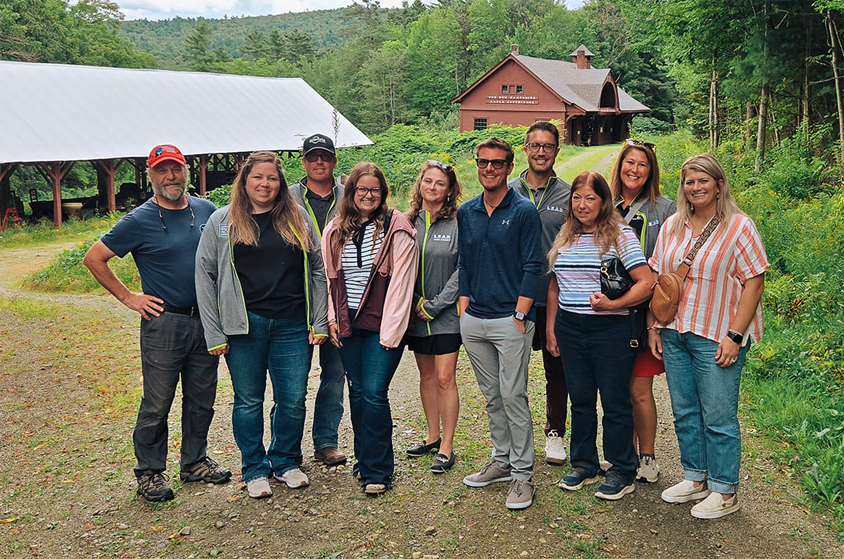 A group of individuals outdoors smiling at the camera.