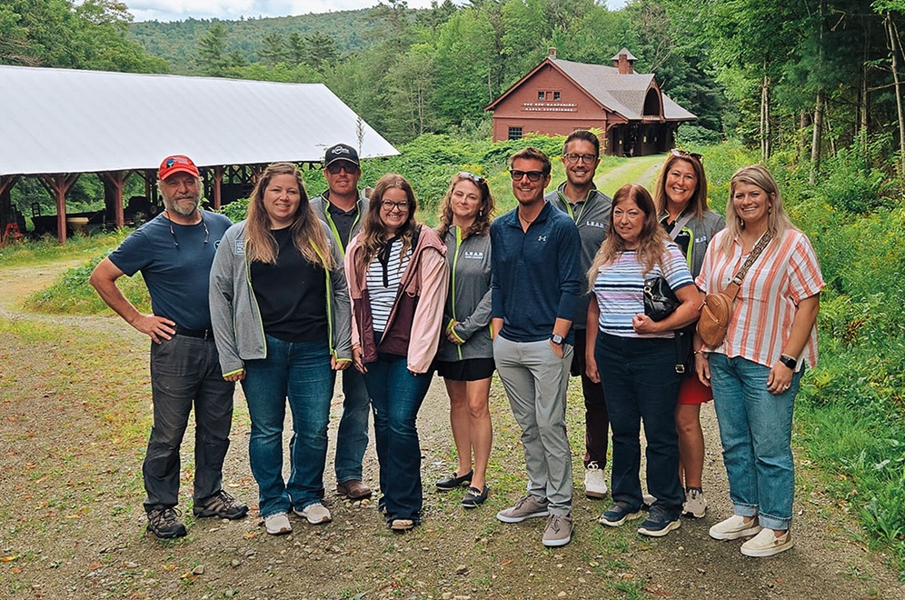 A group of individuals outdoors smiling at the camera.