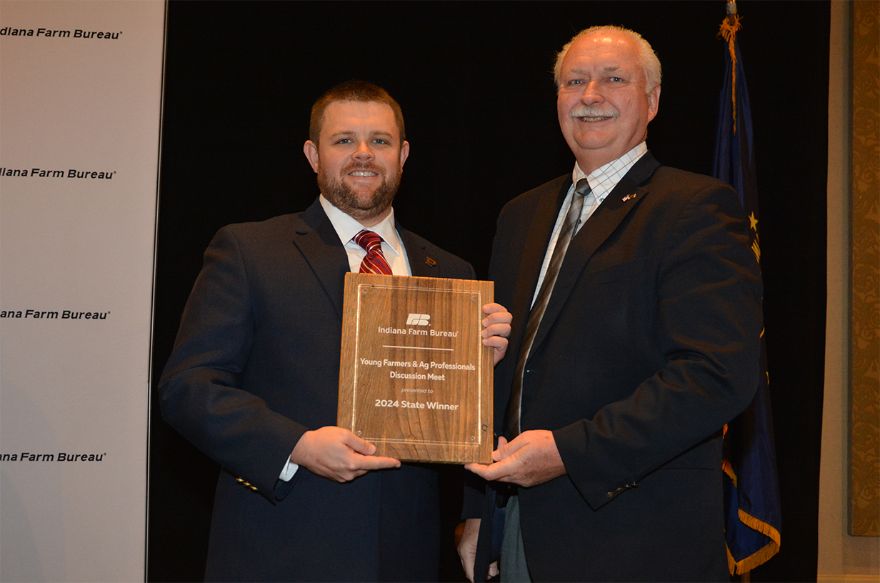 Two men holding an award.