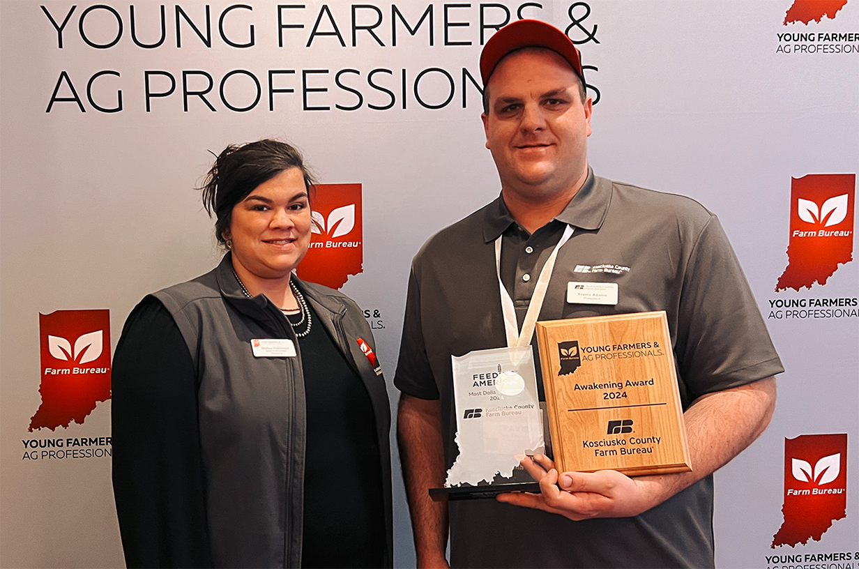 Two adults posing with awards.