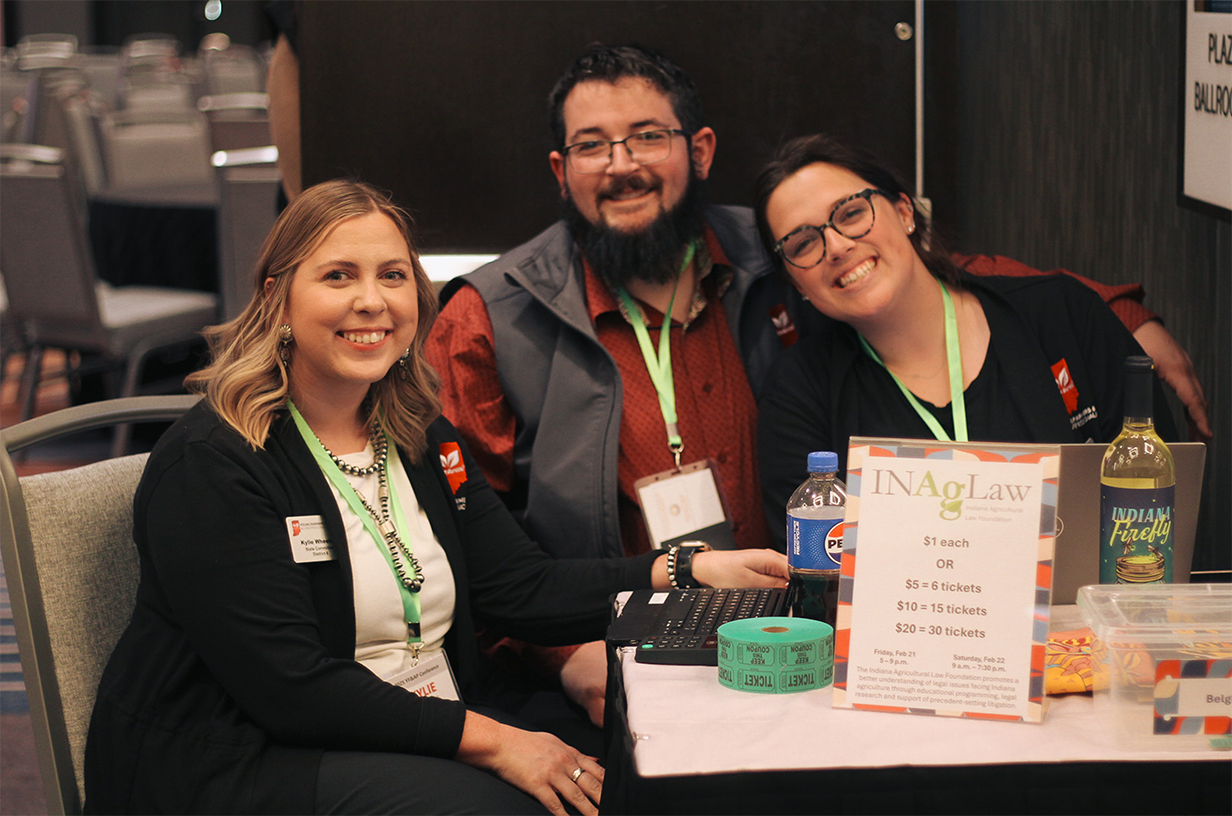 Adults sitting at a table smiling at the camera.