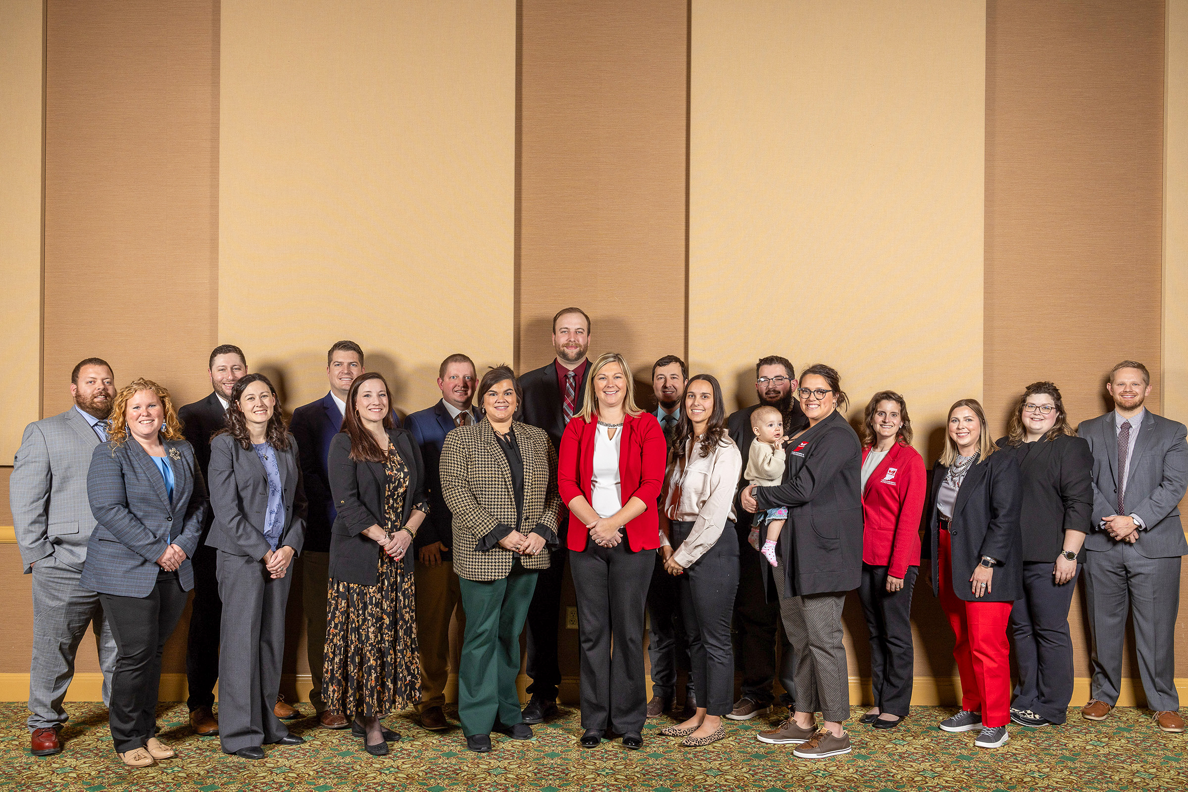 A group of individuals in professional suits and clothing.