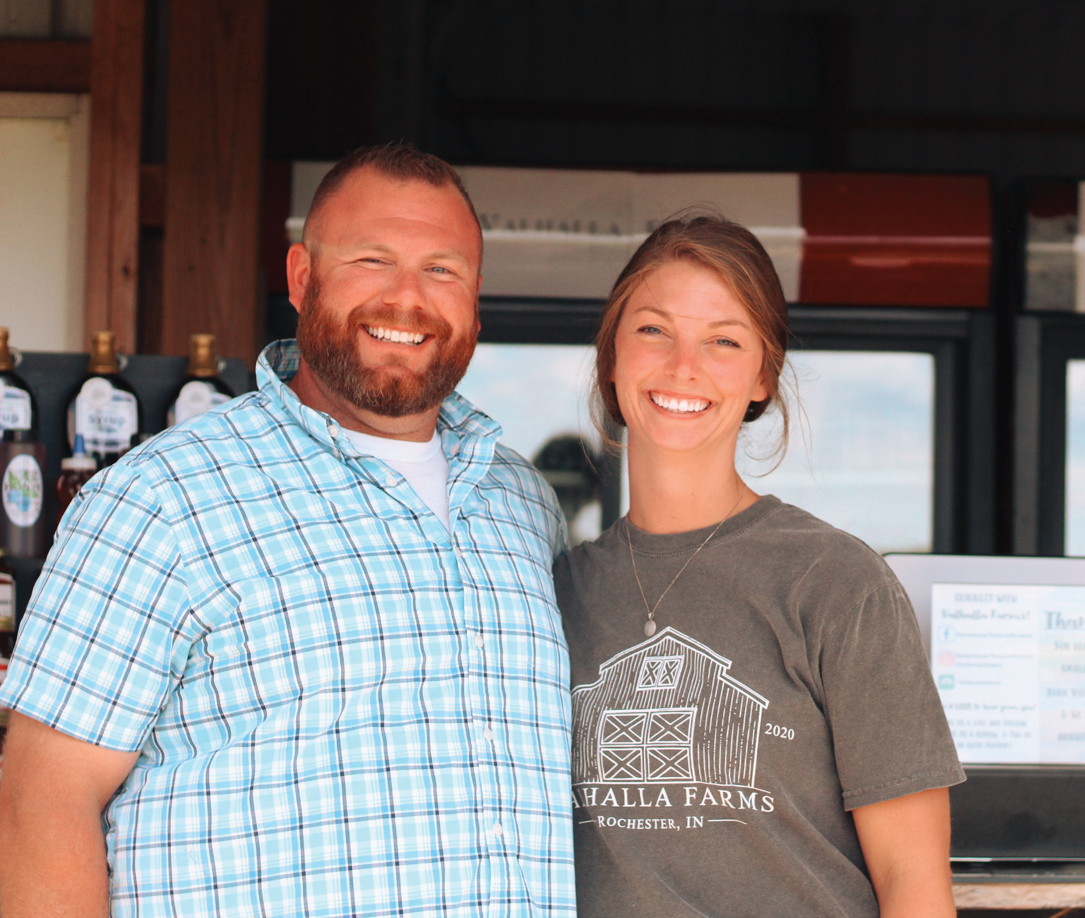 A man and woman smiling at a farm store.