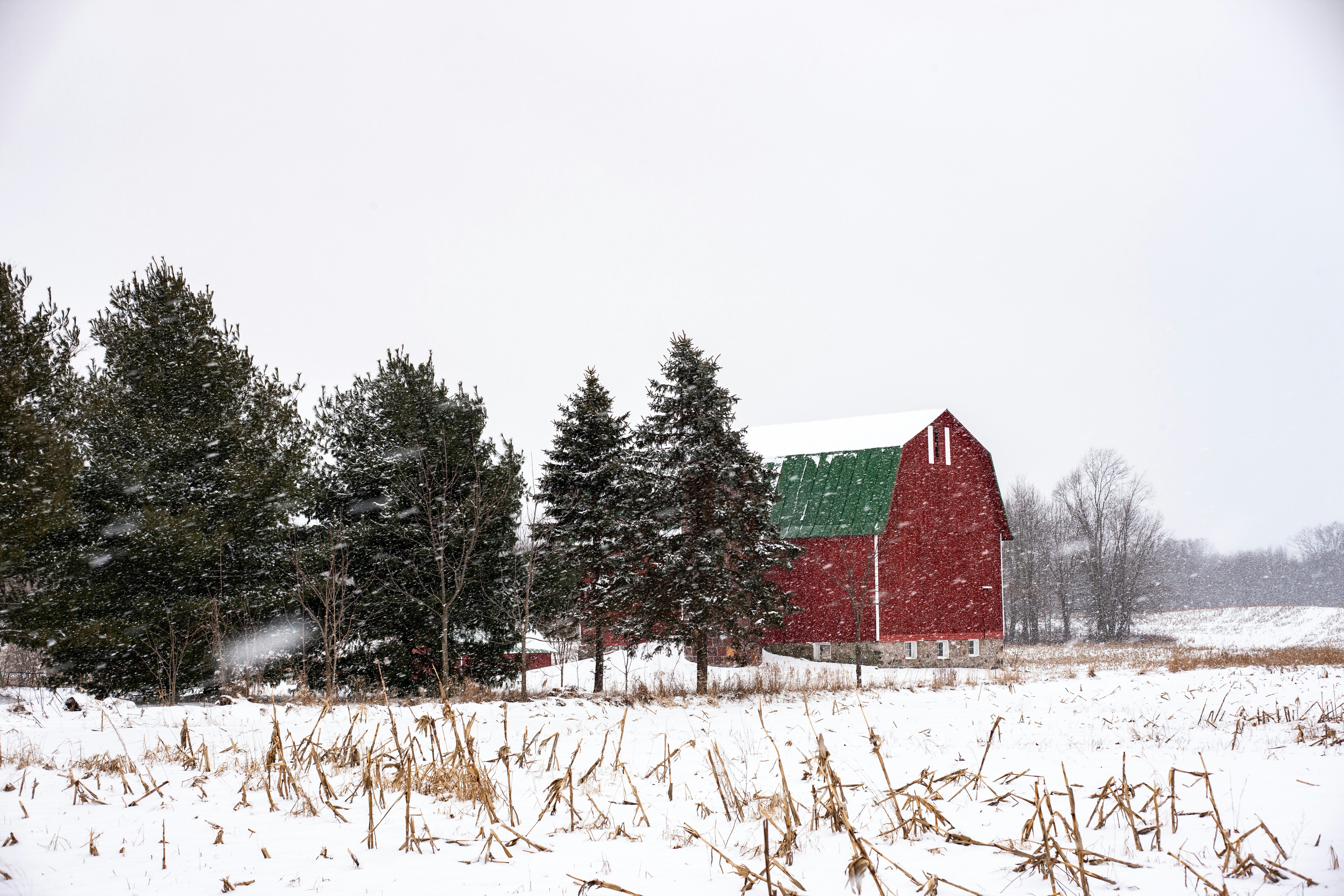 Red barn in Indiana field during a snow storm